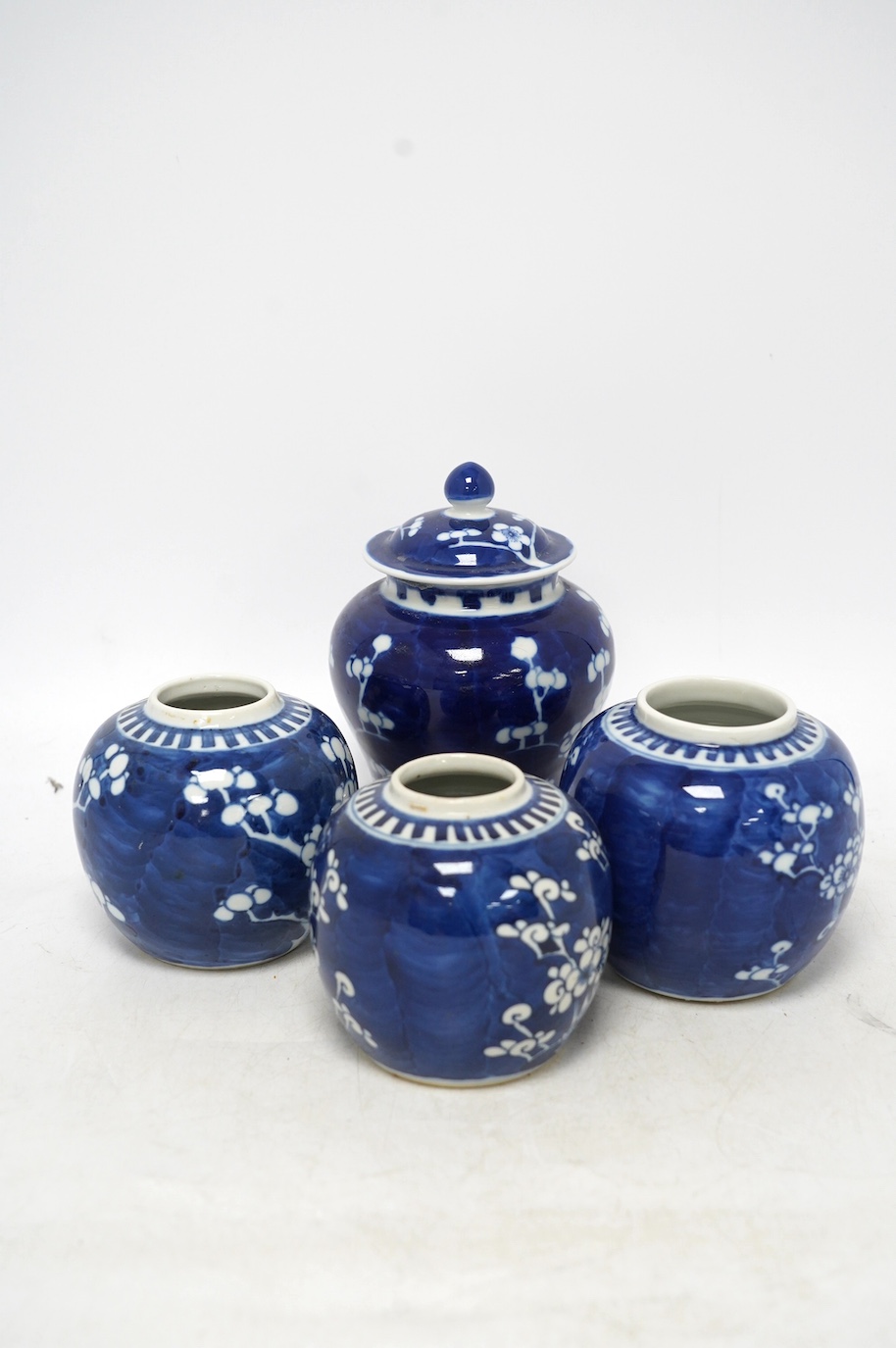 Three Chinese blue and white prunus jars and a similar vase and cover, early 20th century, vase 16.5cm high. Condition - poor as all three jars have the covers missing